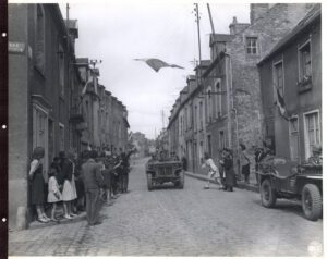 The French flag flies as American troops capture Carentan