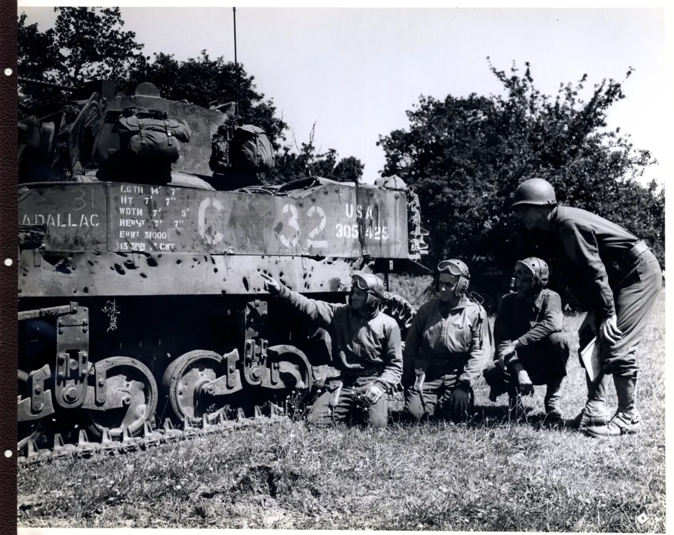 Soldiers examine the holes caused by shells on their tank