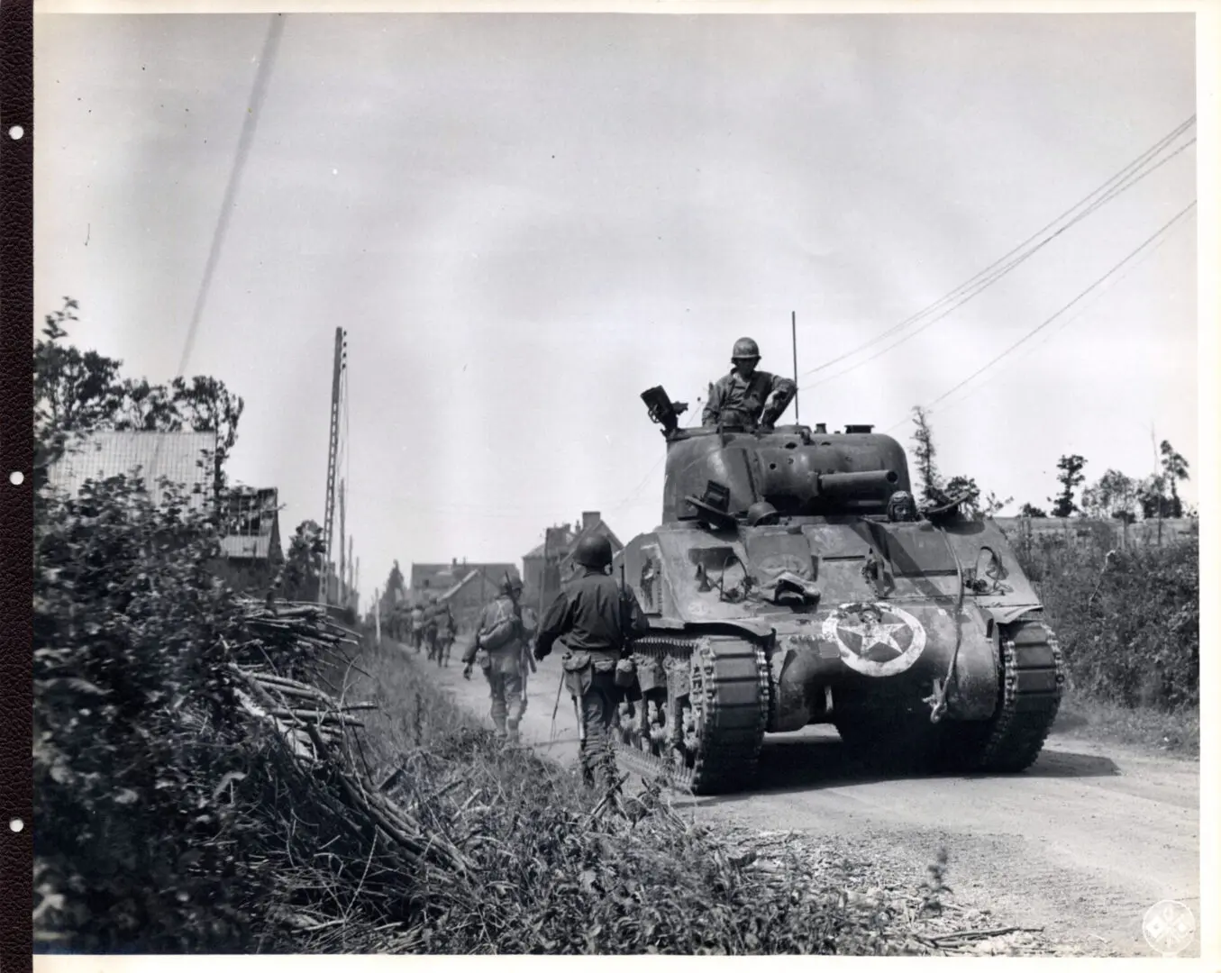 American tank passes by troops getting a break from duty