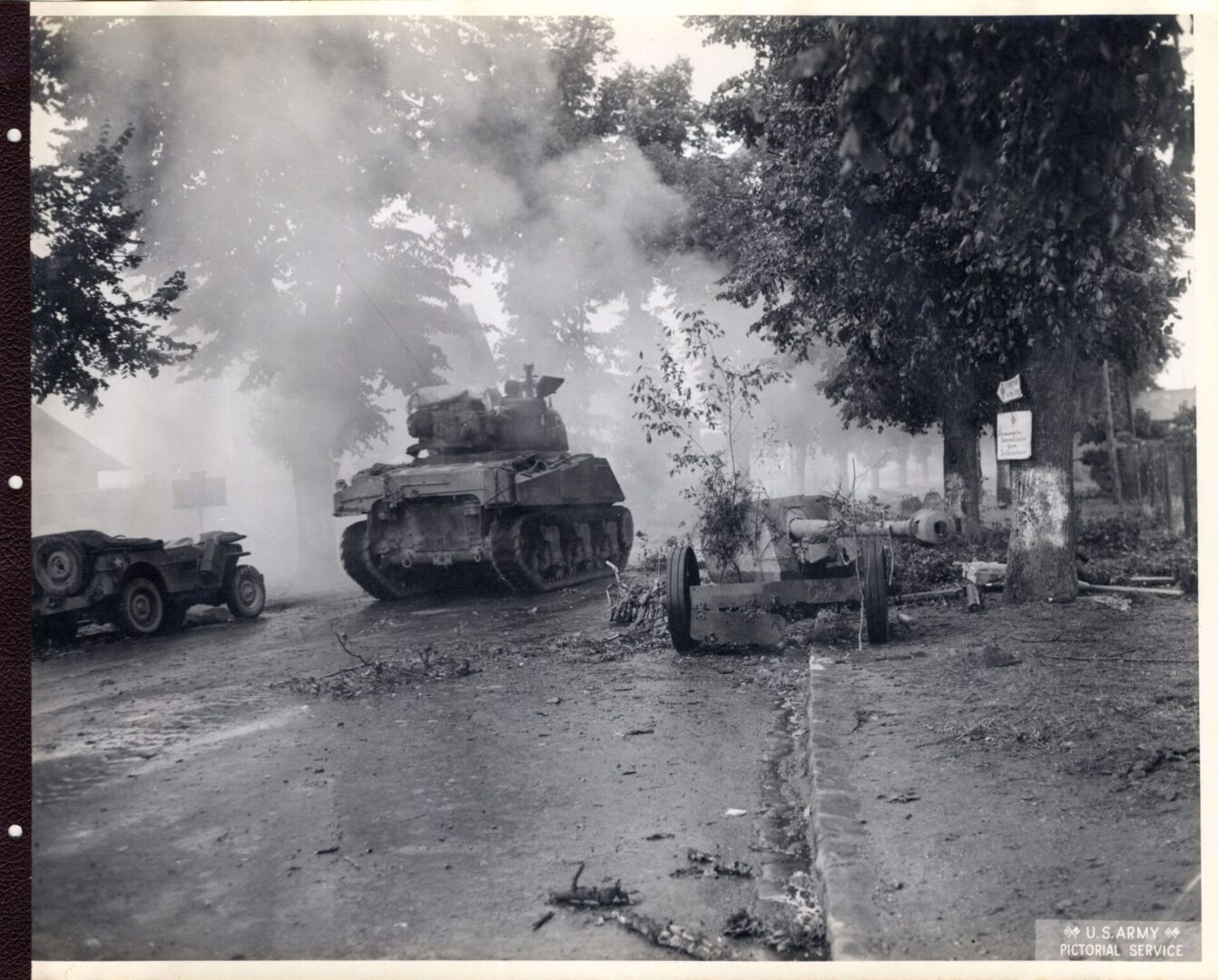 Armored vehicles passing through a ruined French town
