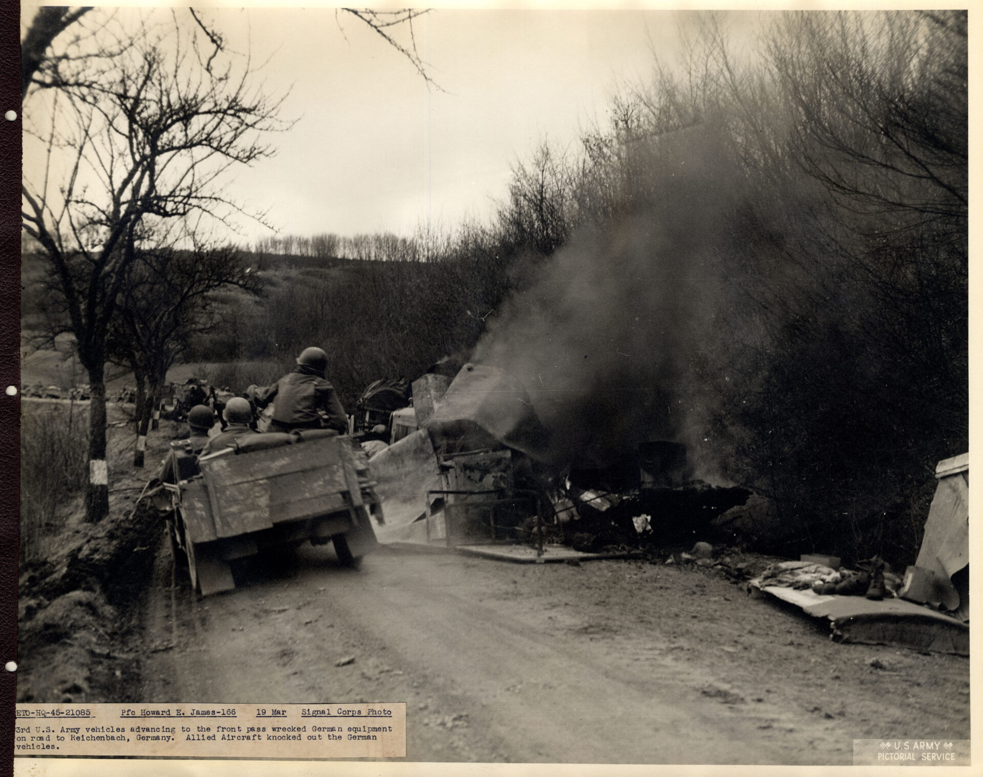 Troops passing wrecked German equipment