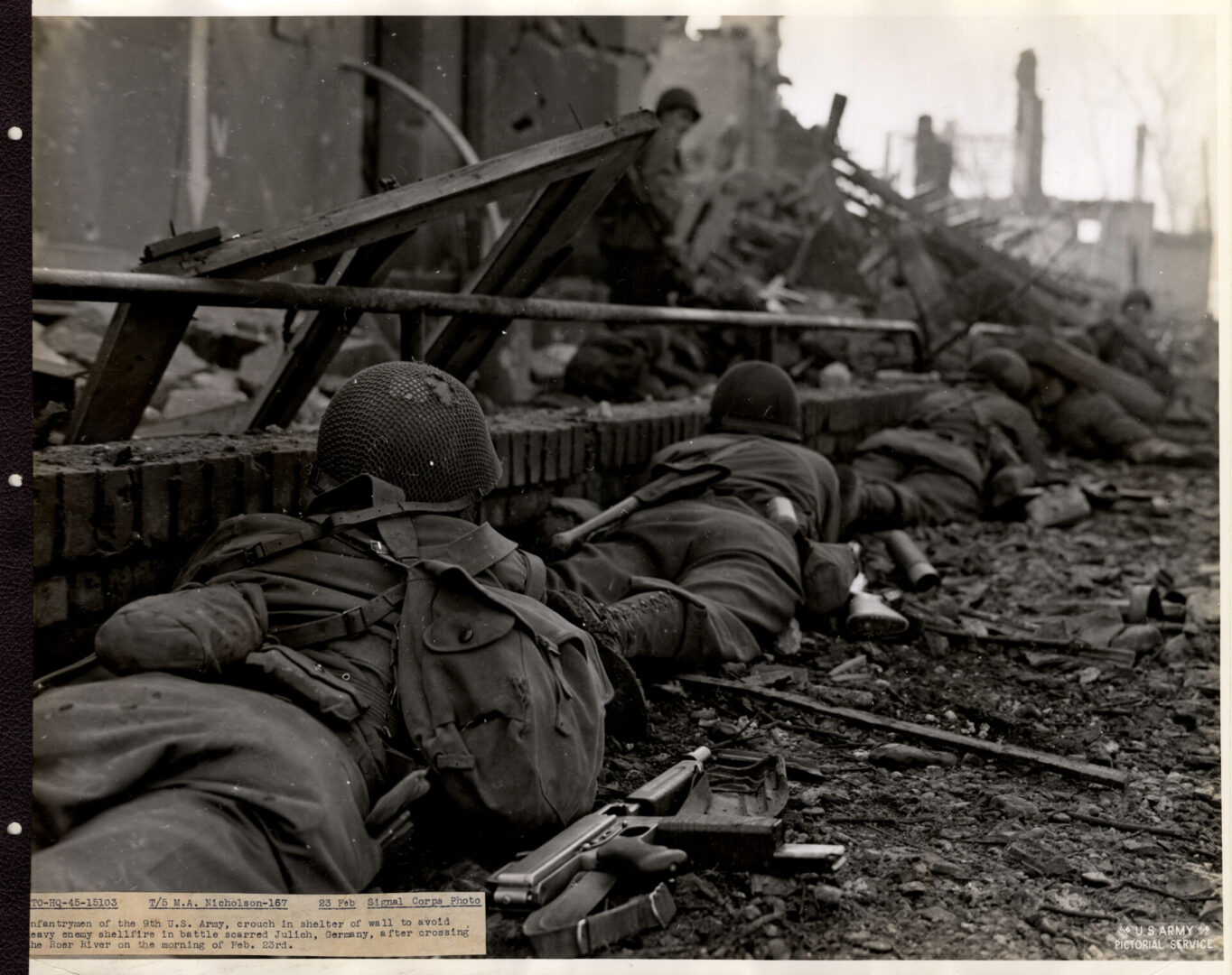 Infantrymen take shelter against a wall during heavy firing