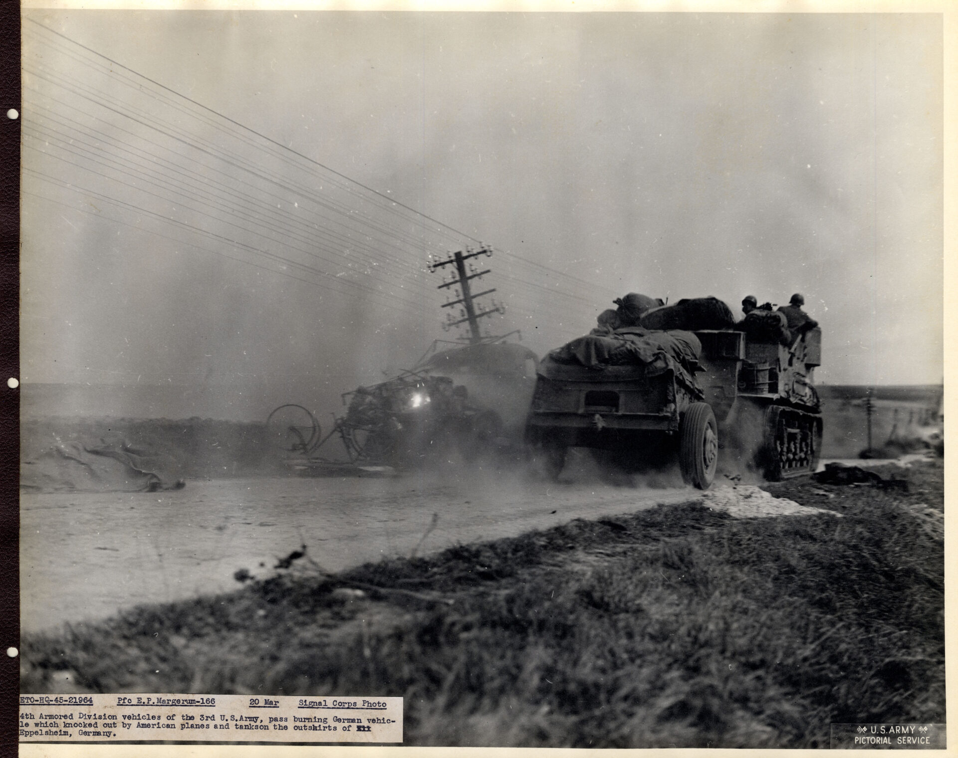Armored vehicle passing a burnt German vehicle
