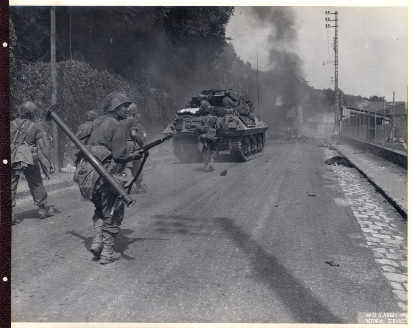 American infantrymen move past dead German soldiers