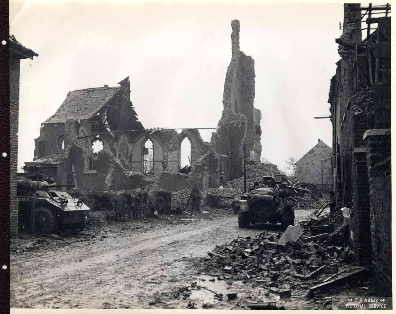 Infantrymen moving through a wrecked town in France