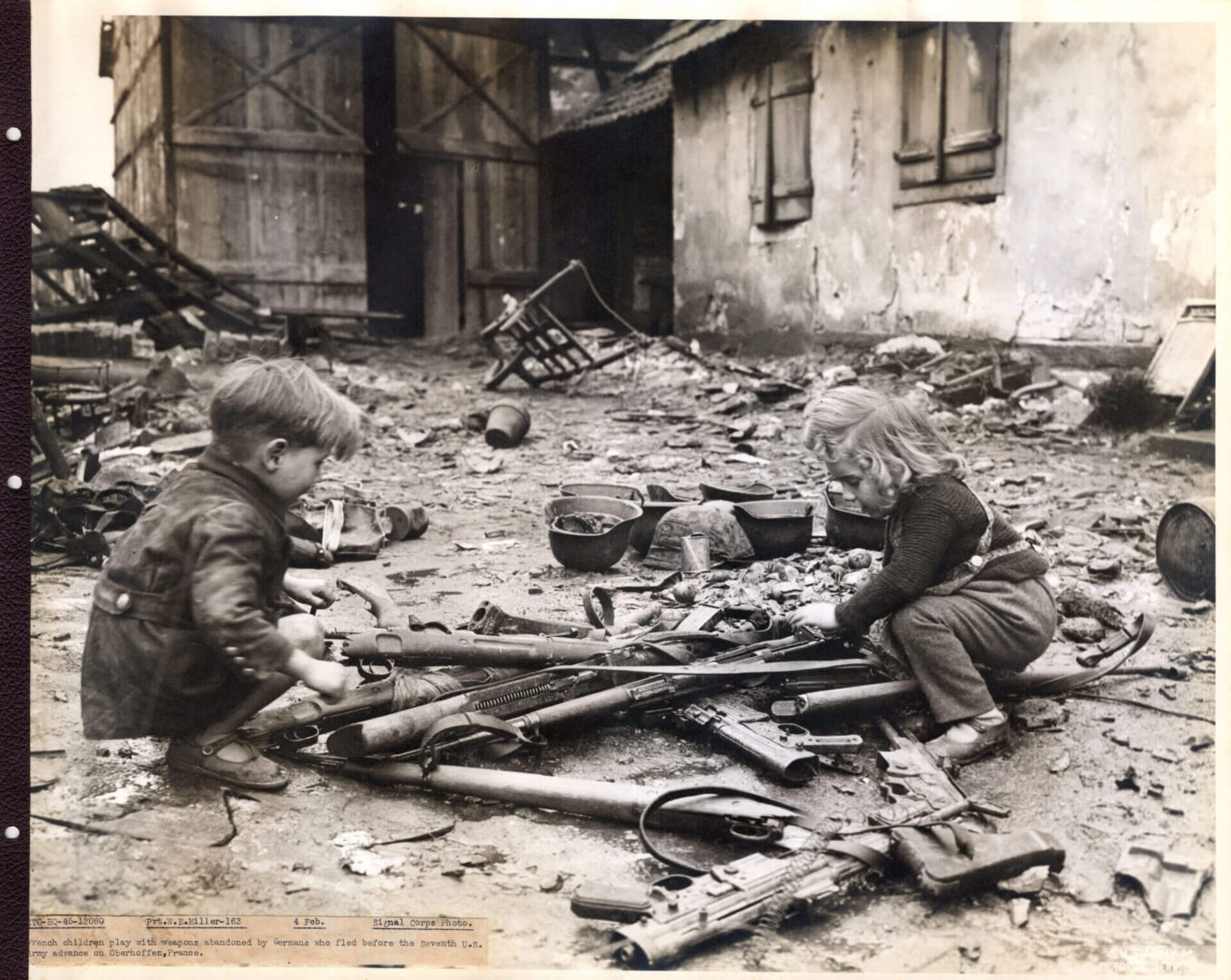 Two children playing with destroyed ammunition
